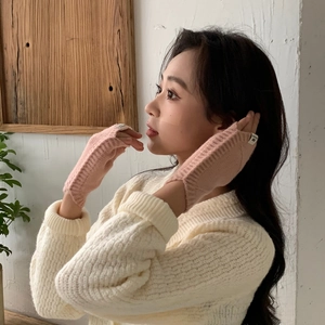 Gros plan sur les mitaines roses en tricot côtelé doux avec petite étiquette décorative