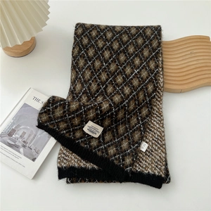 Détail d'une écharpe d'hiver en tricot à losanges marron et noir avec étiquette de marque