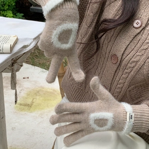 Détail de gants en tricot avoine avec décor en peluche blanche et poignet en maille côtelée