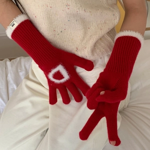 Détail de gants en tricot rouge avec poignets en fausse fourrure et décor lettre D