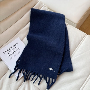 Gros plan d'une écharpe en maille bleu foncé avec texture douce et des franges