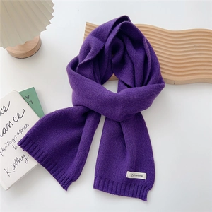 Detail view of purple knitted scarf with cashmere label and fine ribbing texture