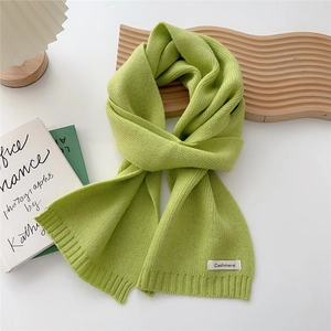 Detail of grass green cashmere knitted scarf showing ribbed edge and woven label