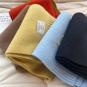 Detail von Wollstrickschals in mehreren Farben mit gewebten Etiketten und Rippenstruktur