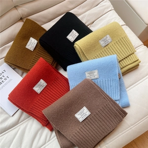 Dicke gestrickte Wollschals in verschiedenen Farben mit gewebten Etiketten für den Winter