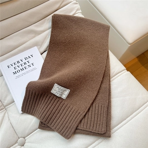 Detail eines Strickschals aus 100% Wolle mit Rippenstruktur und Stoffetikett