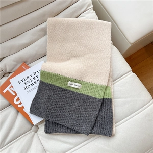 Detailed view of the dense rib knit texture and tri-color patchwork on the scarf