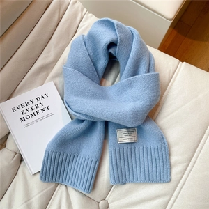 Detailansicht hellblauer Strickschal aus Wolle mit hochwertigem 100% Wollstoff-Etikett