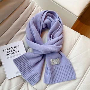 Detailansicht der helllila Strickschal aus 100 % Wolle mit weicher Textur und Etikett