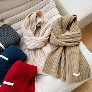 Close-up of knit wool scarves in multiple colors with 100% wool material label