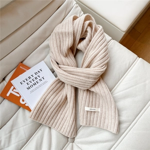 Detailed macro view of 100% wool cream white scarf showing premium ribbed knit texture