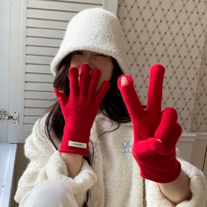 Close-up of red 100% wool knit gloves featuring a fingerless touchscreen design
