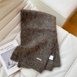 Close-up of colorful alpaca wool knit scarf with soft fluffy texture and metal brand tag