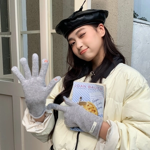 Detail of light gray wool knit gloves with finger openings for easy screen operation