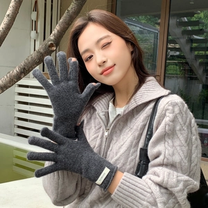 Detail of dark grey wool gloves showing the touch screen opening on thumb and index finger