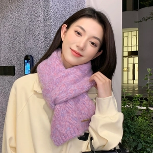 Close-up of thick knitted winter scarf with purple-pink cable pattern on female model