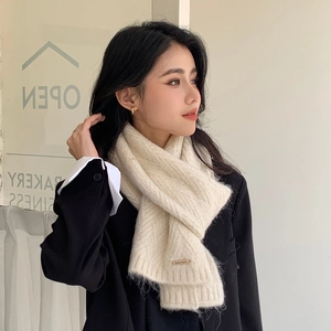 Detail of cream white chunky knit winter scarf with V-pattern and leather brand tag