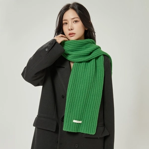 Vibrant green 100% wool knitted scarf with ribbed texture over a black coat