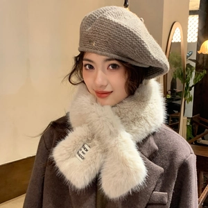 Detail of grey knit beret and cream faux fur scarf set with elegant metal logo charm