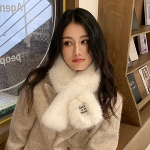 Detail of white faux fur cross scarf with fashion label on beige wool coat
