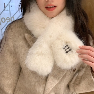 Detail of soft cream faux fur scarf with fashion label on a wool tweed coat