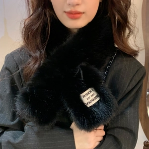 Detail of black faux fur scarf with white fashion label on striped suit jacket