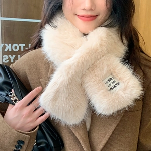 Detail of soft faux rabbit fur scarf in beige with a stylish fashion letter patch