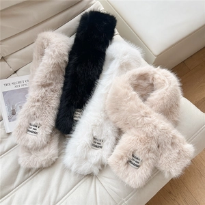 Detail of four faux fur scarves in black, white, beige and brown with brand woven labels