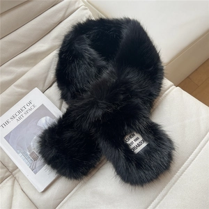 Close-up of black faux fur scarf featuring a white fashion brand label on soft leather