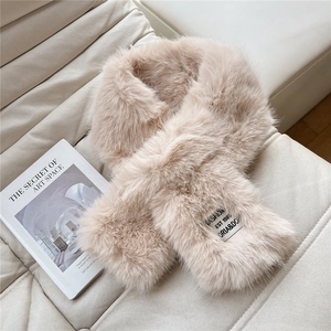 Detail of soft beige faux fur scarf showing the fashion label and plush texture