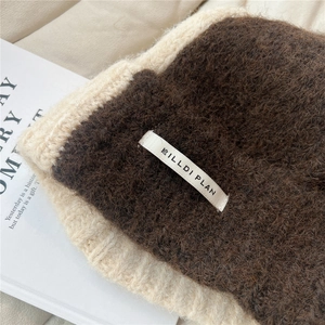 Detail of soft knitted beanies in brown and beige with Hilldi Plan woven labels