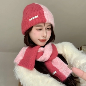 Detailed close-up of pink knit scarf and beanie set with fuzzy texture on model