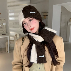 Detail of soft knit texture on two-tone brown and cream beanie and scarf set