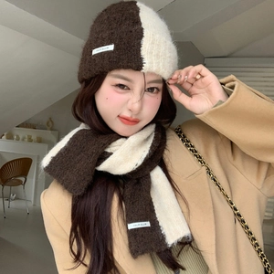 Detail of soft knit texture on brown and cream color-block scarf and hat winter set