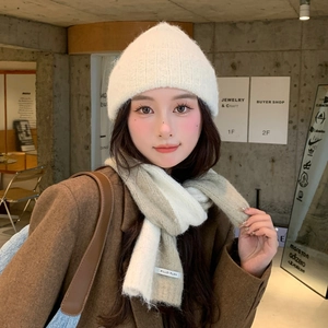 Close-up of knit texture on white beanie and beige brown two-tone winter scarf