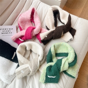 Detailed close-up of thick knitted scarves with two-tone splicing and cross-buckle design