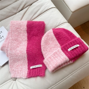 Close-up of knit scarf and hat set with fuzzy texture and pink color-block design