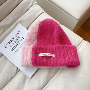 Detail of pink two-tone knit beanie with soft mohair texture and brand label
