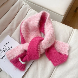 Detailed knit texture of pink and magenta contrast scarf with soft brand label