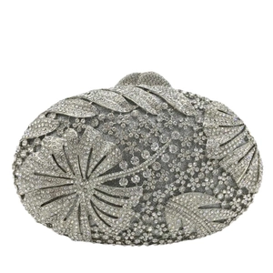 Macro detail of silver floral evening clutch bag featuring intricate crystal rhinestones