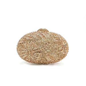 Macro detail of luxury floral rhinestone patterns on a champagne gold evening clutch bag