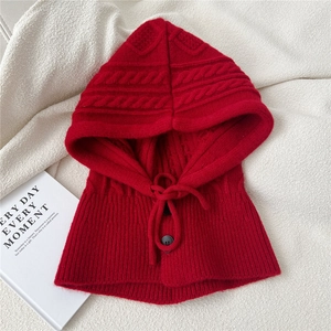 Close-up of deep red knitted balaclava hood with cable knit texture and black buttons