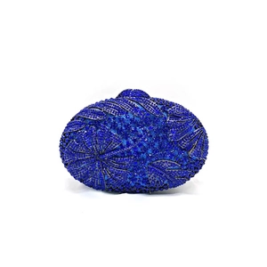 Detailed view of deep blue rhinestone encrusted evening clutch with leaf-like textures