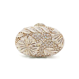 Close-up of champagne gold floral evening clutch with hollow crystals and rhinestones