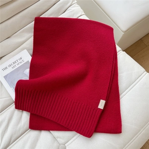 Dettaglio sciarpa rossa 100% lana che mostra la trama a maglia e la finitura a coste