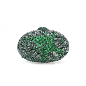 Detailed view of emerald green and black rhinestones in a leaf pattern on a clutch bag