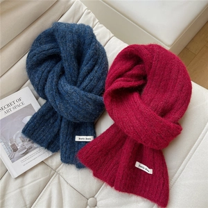 Detailed texture of thick navy and burgundy knitted scarves with brand labels