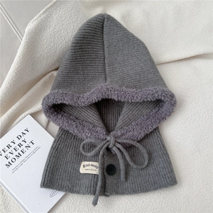 Detail of grey knitted balaclava showing thick purple fleece lining and button closure