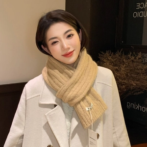 Detail of light khaki ribbed knit scarf showing soft thick texture and woven labels