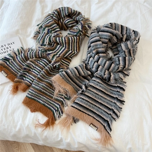Thick striped knit wool scarf with fringe and vintage woven label on white background